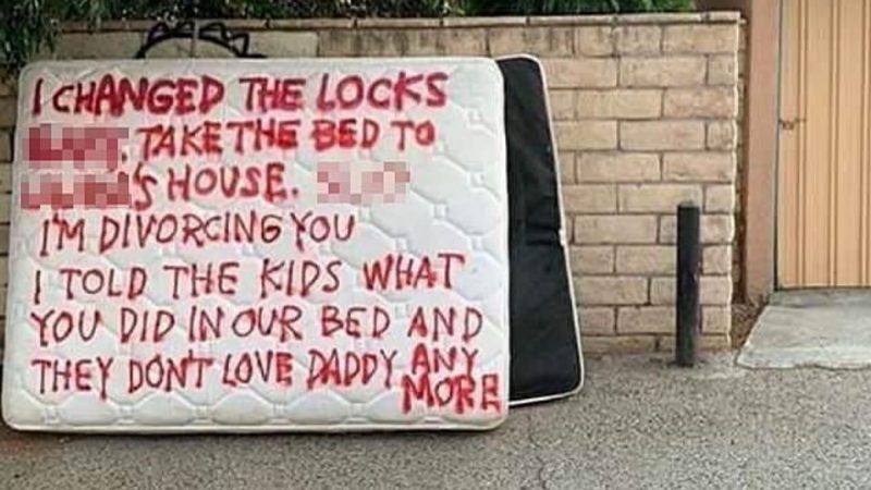Wife shames cheating husband by spray painting brutal message on their mattress outside their house