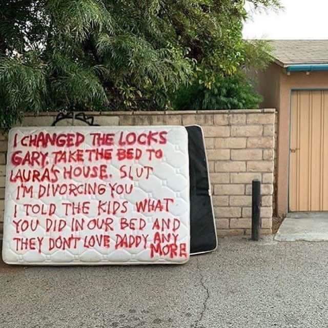 Wife shames cheating husband by spray painting brutal message on their mattress outside their house